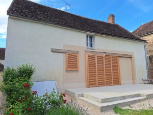 Volets coulissants formant brises soleil sur porte-fenêtre dans rénovation d'une maison existant située près de venouse